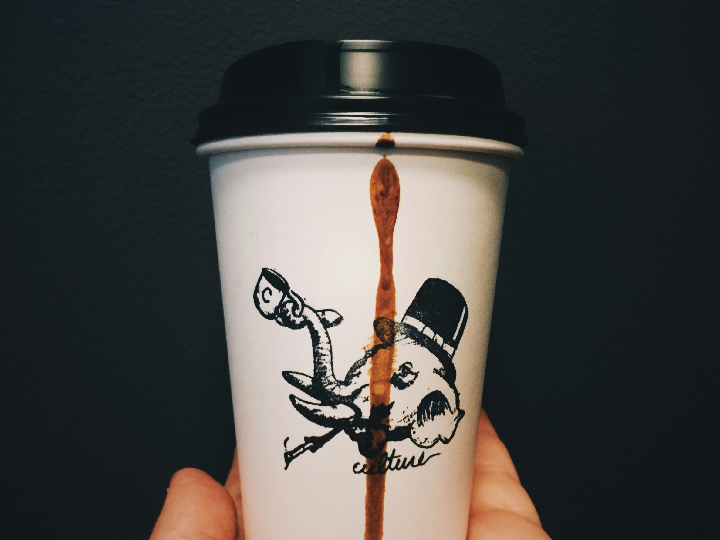 person holding black and white disposable cup